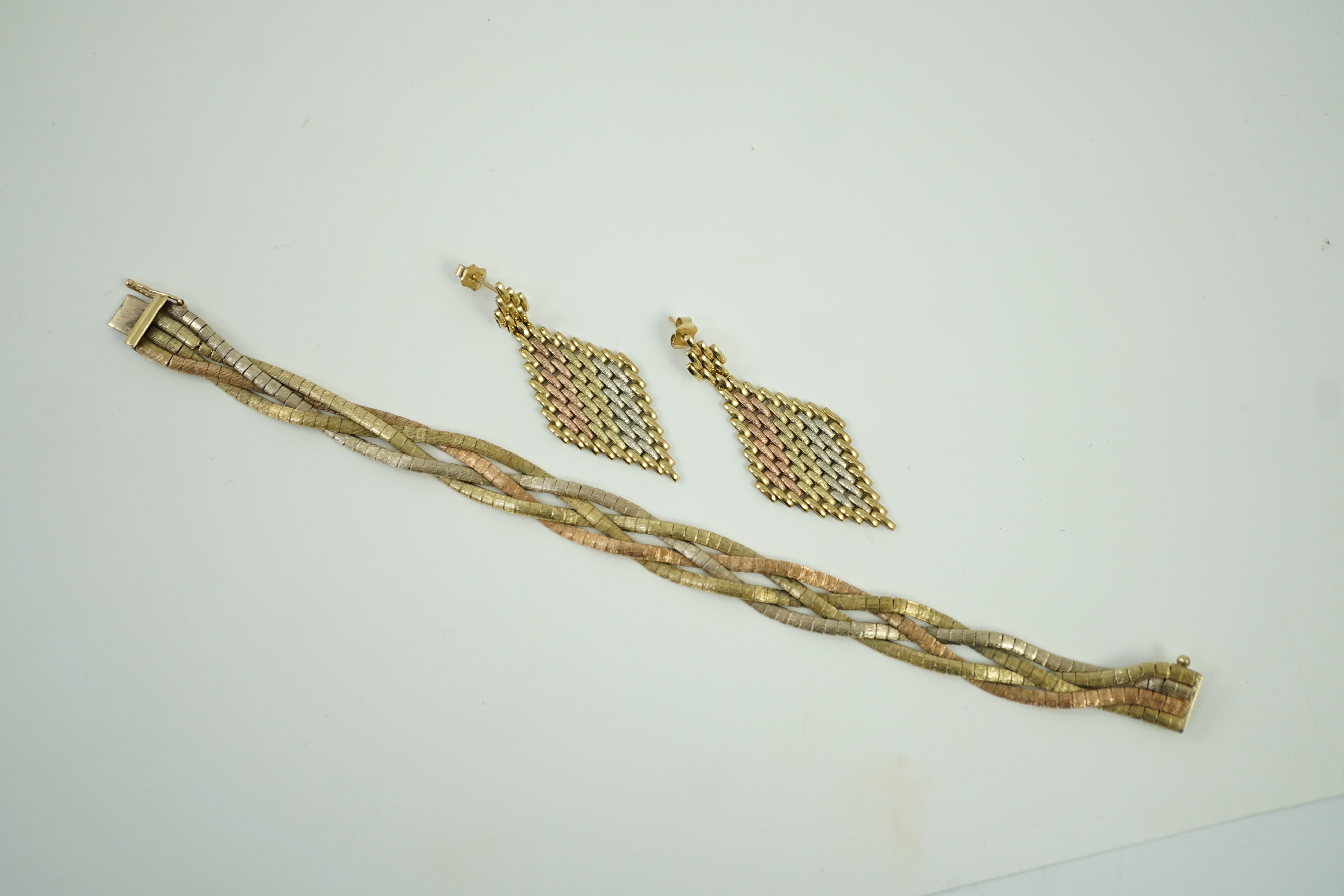 A modern three colour 9ct gold interwoven bracelet, 18.5cm and a pair of similar 9kt drop earrings, 30.6 grams.